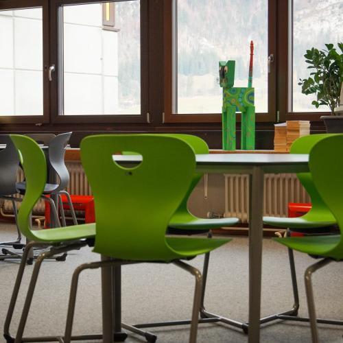 Detailansicht der grünen Stühle rund um den Tisch in der Bücherei